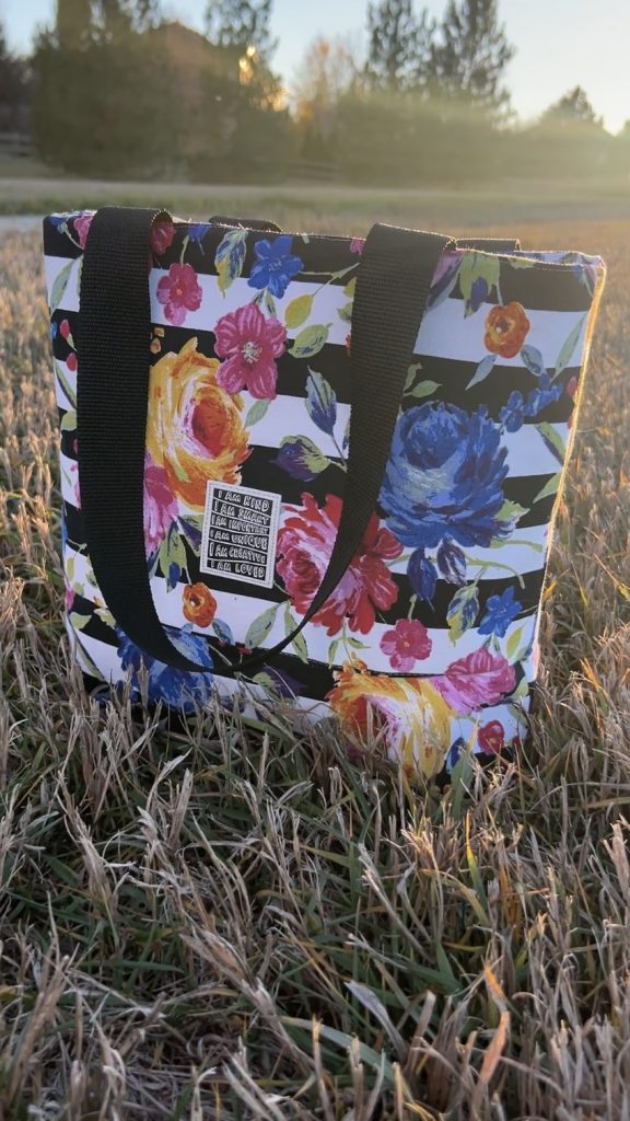 Tote with black and white stripes with bright floral print and black straps