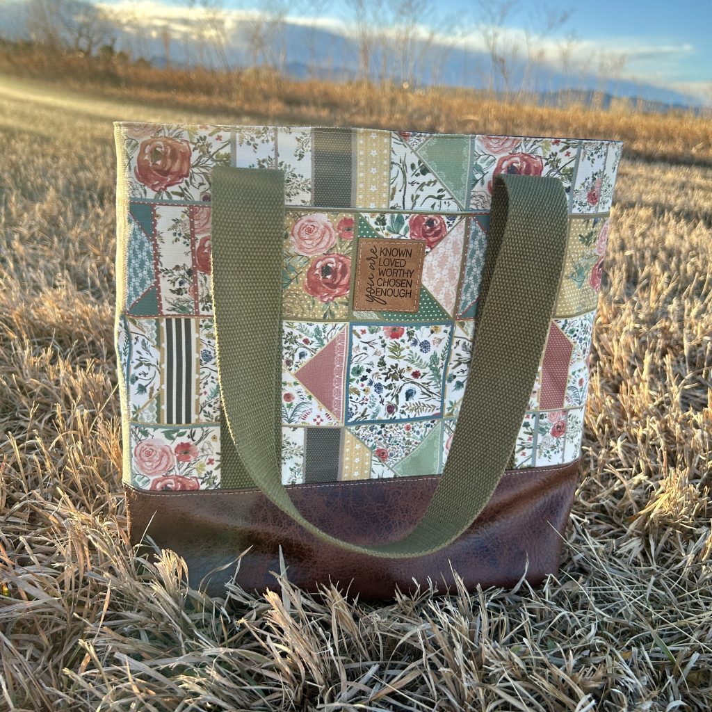 Tote with faux patchwork quilt print and green straps